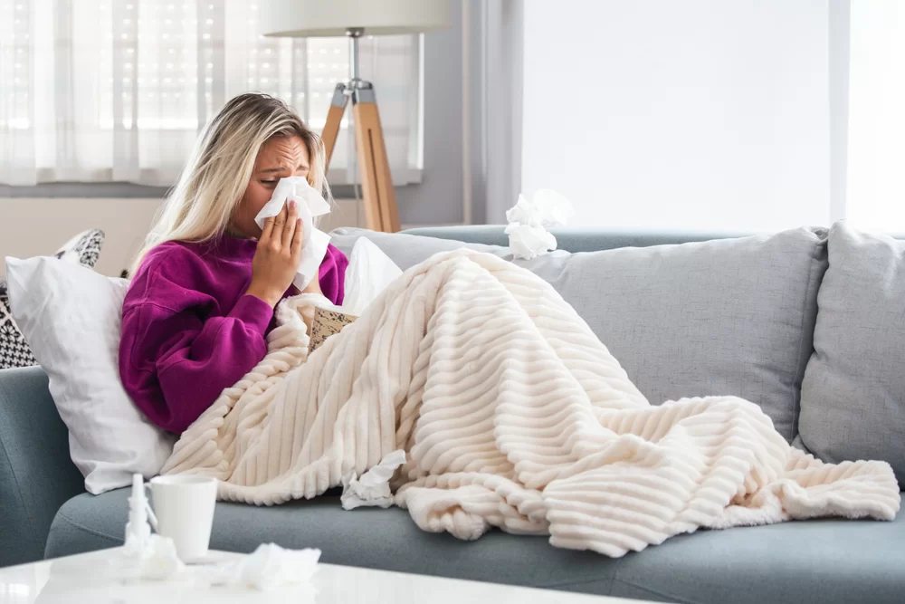 Employee resting on the couch after texting in sick