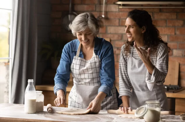 A woman and her grown daughter cooking together
