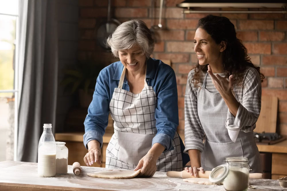 A woman and her grown daughter cooking together