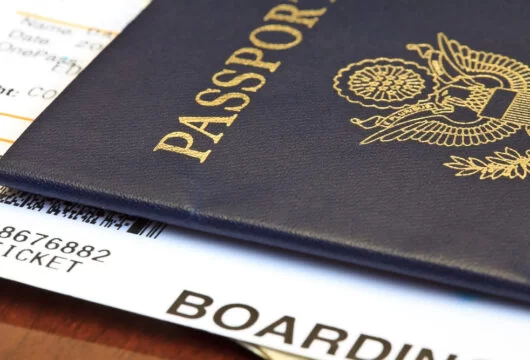 Close-up of a person's passport and boarding pass for a trip abroad