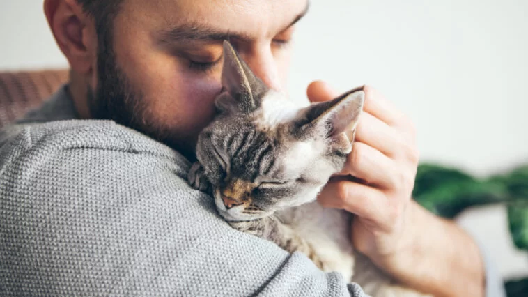 Man hugging a short-haired cat