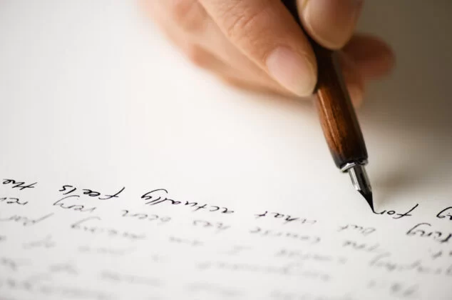 Close-up of a parent's hand writing a letter to a daughter making bad choices