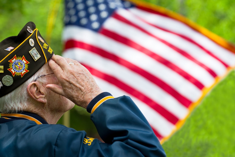 Elderly veteran saluting an American flag