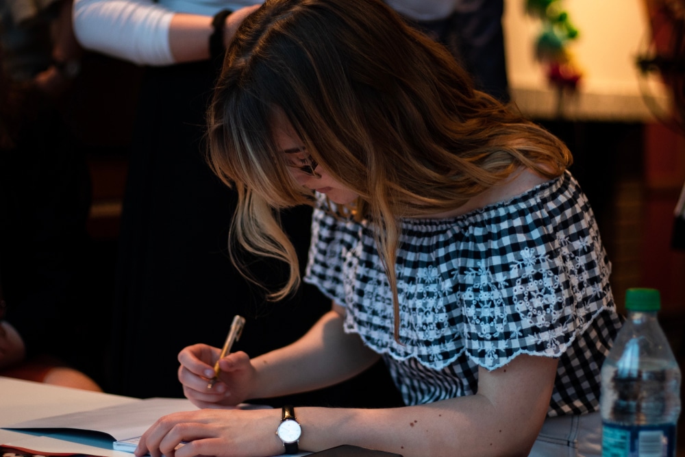 Young teacher signing a student's yearbook