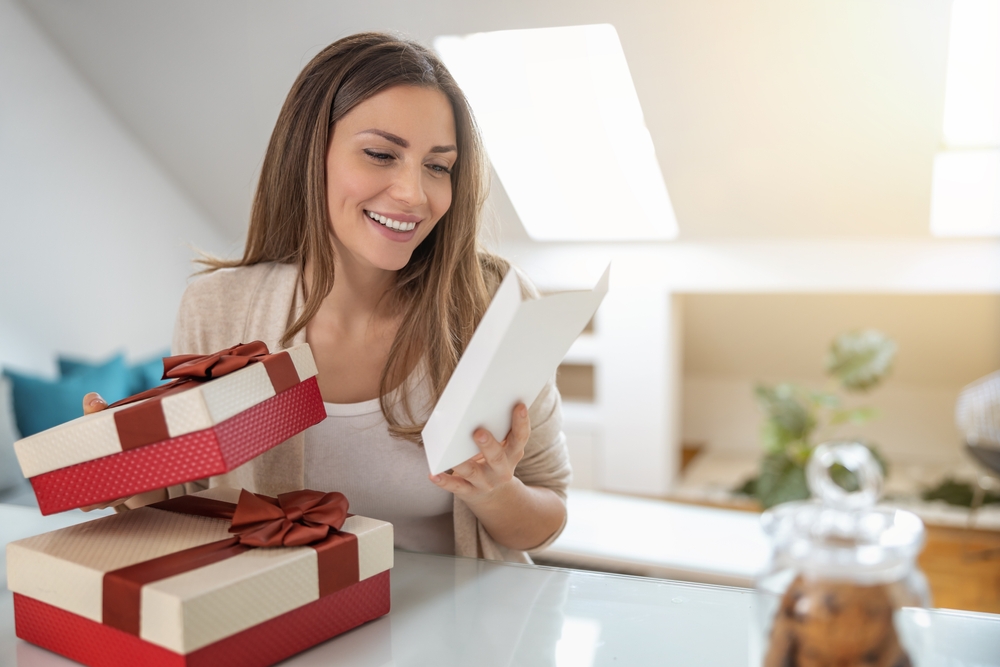 Woman opening a belated birthday gift and card from her cousin