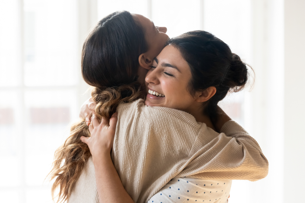 Woman hugging her unbiological sister on her birthday