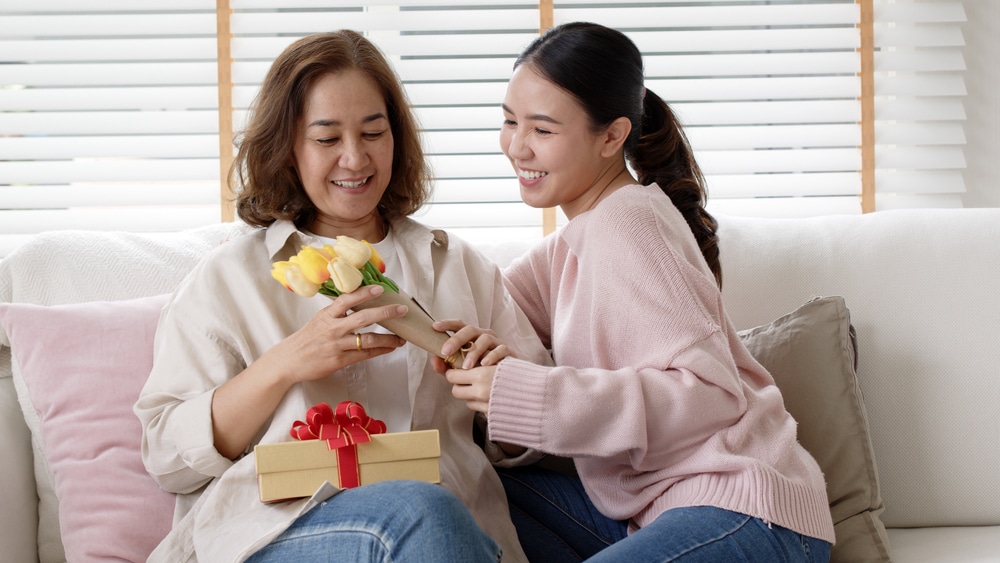 Young woman giving her mom a mother's day/birthday present