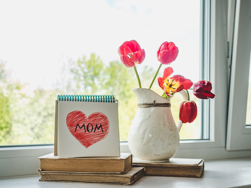 Mother's day gifts and flowers displayed in front of a window