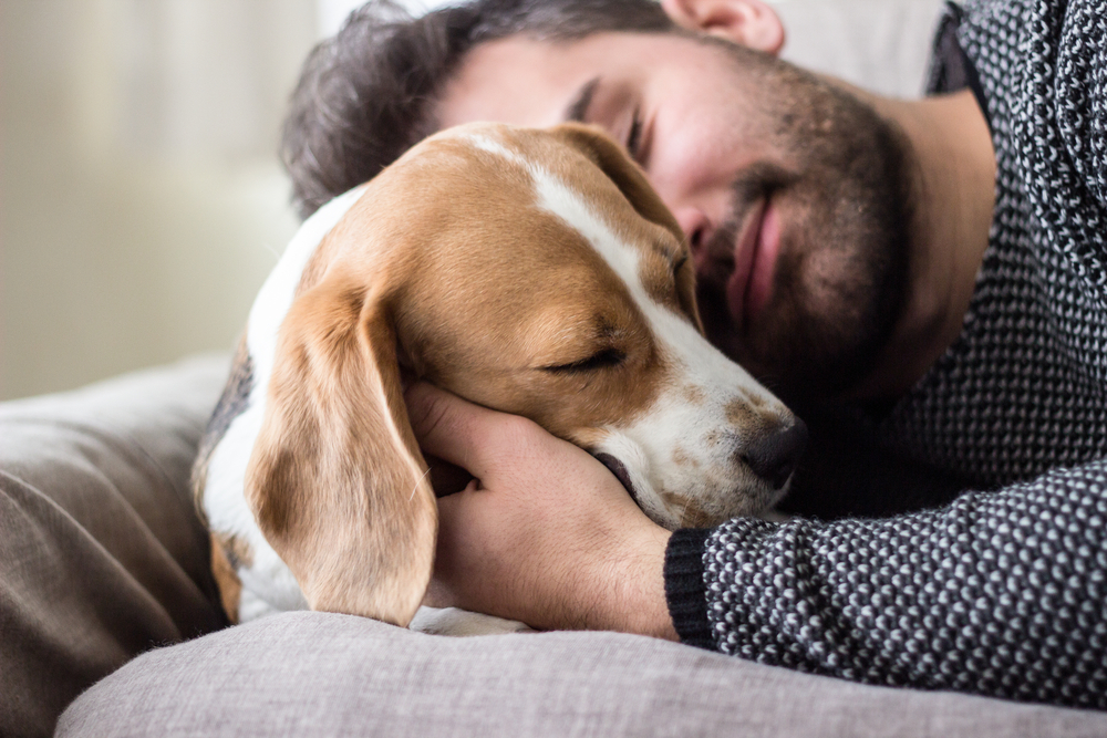 Man snuggling with his dog