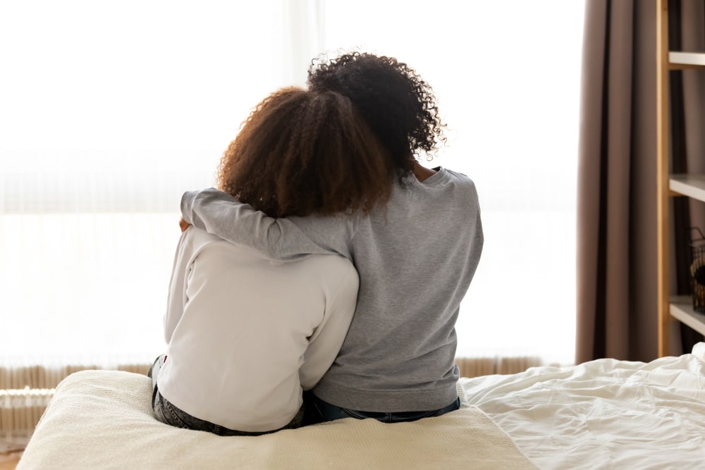 Sisters hugging and comforting each other with encouraging words