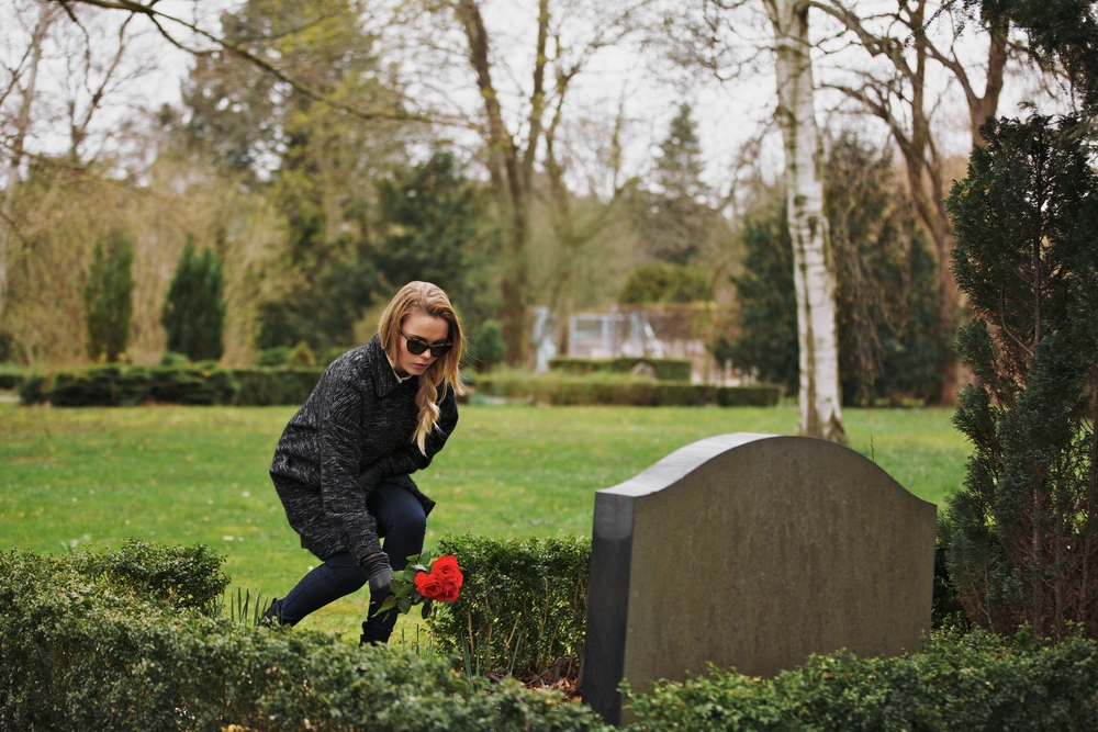 Woman leaving flowers at her brother's grave site