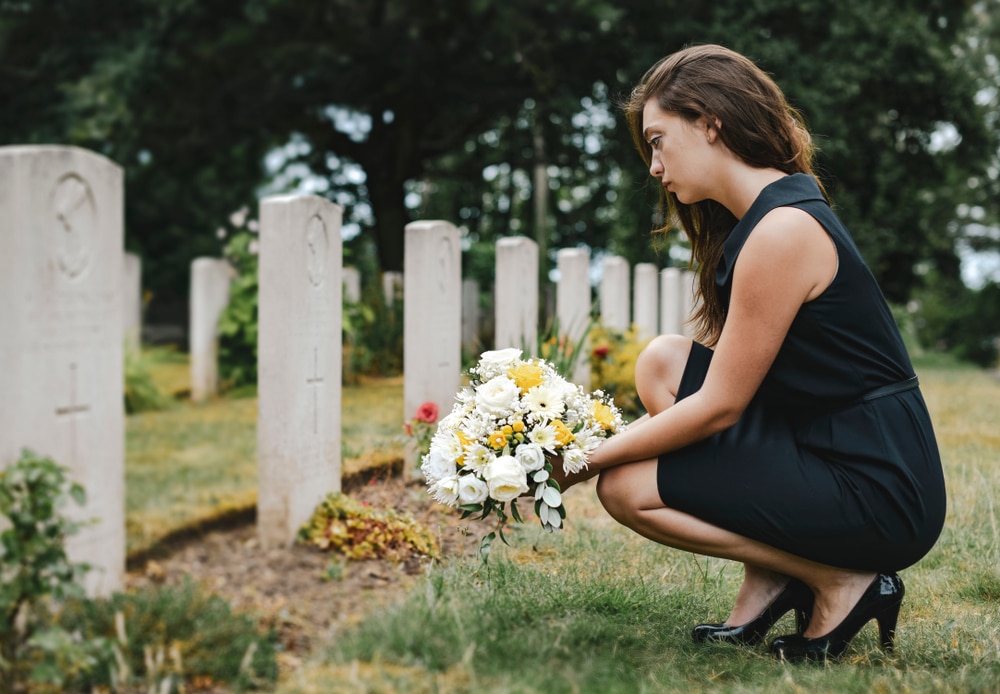 Woman leaving flowers at her sister's grave for Mother's Day