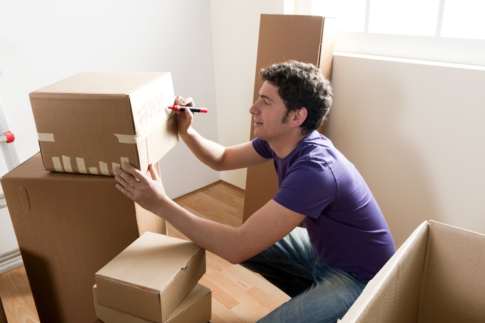 Young man packing boxes to leave for college