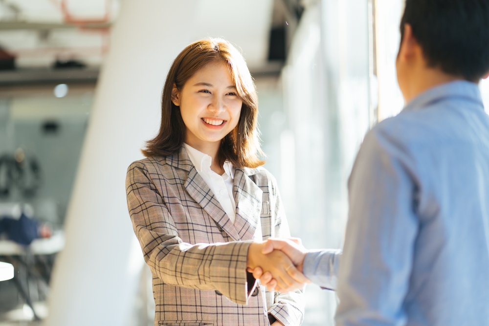 Man and woman greeting one another with a handshake