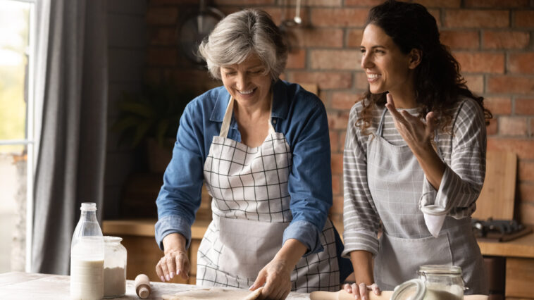 A woman and her grown daughter cooking together