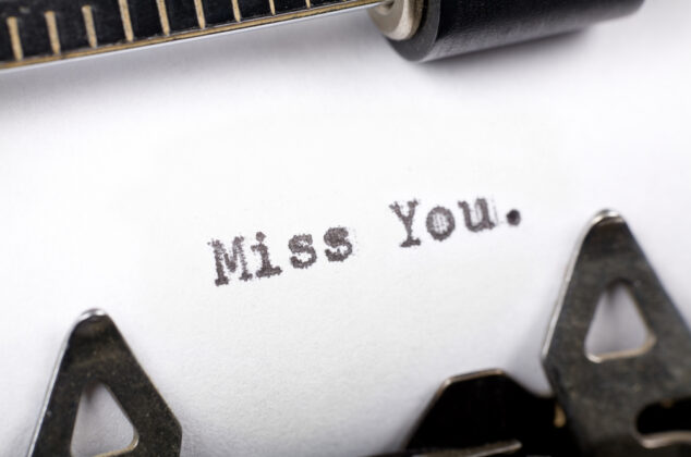 A sheet of paper with the words "Miss You." typed on it with a typewriter