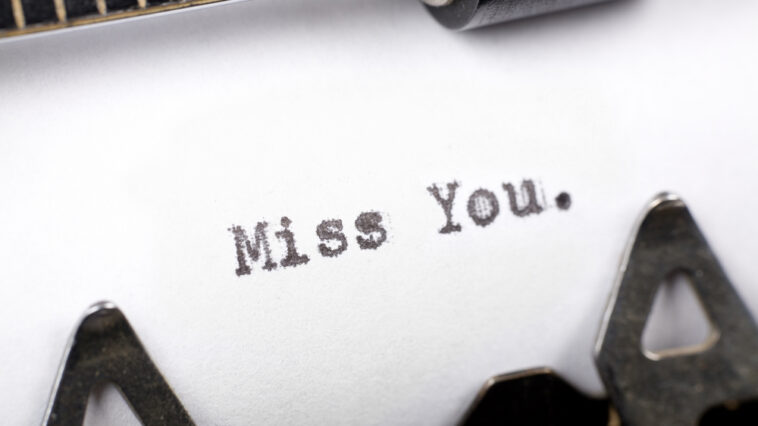 A sheet of paper with the words "Miss You." typed on it with a typewriter