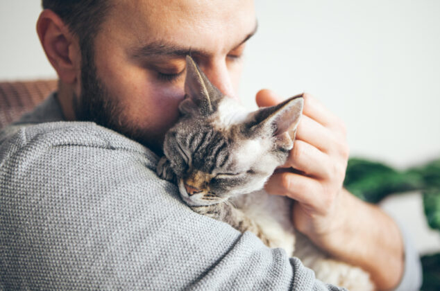 Man hugging a short-haired cat