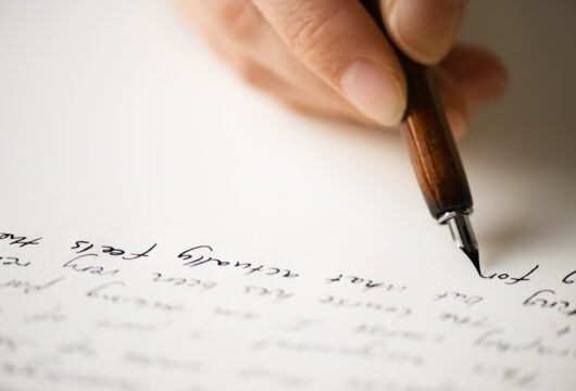 Close-up of a parent's hand writing a letter to a daughter making bad choices